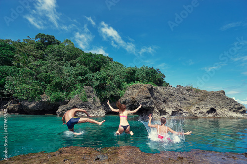 Fototapeta Naklejka Na Ścianę i Meble -  Vacation and activity. Friends jumping on blue tropical lagoon, Siargao Island, Philippines.