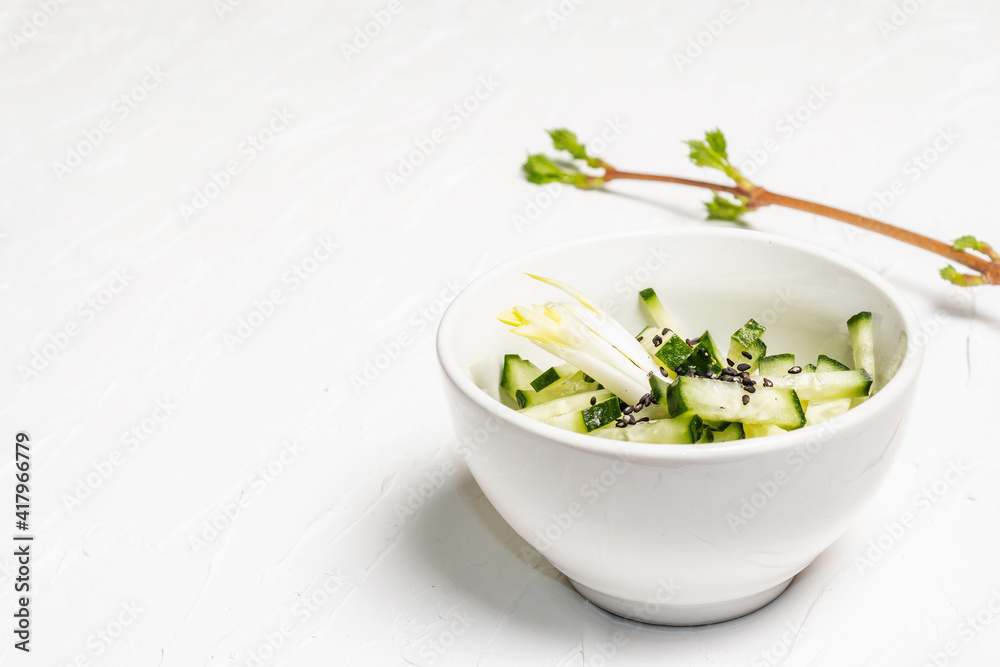 Fresh cucumber salad with sesame seeds in a white ceramic bowl Fresh cucumber salad with sesame seeds in a white ceramic bowl
