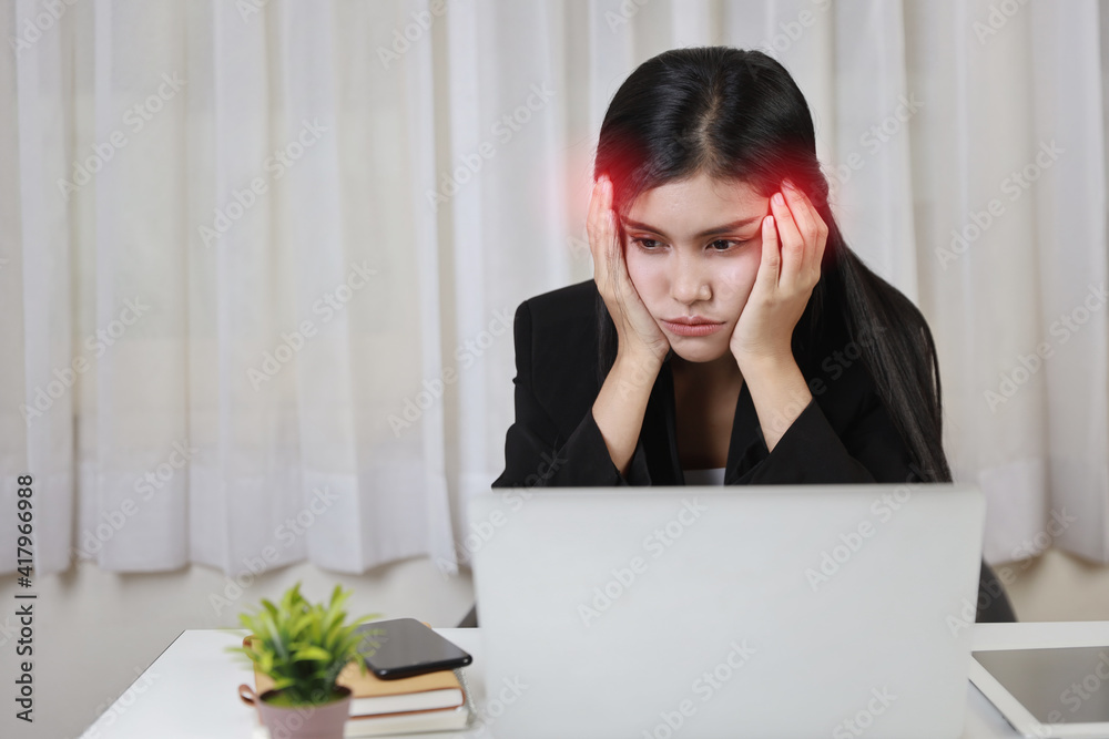 Young asian stressed businesswoman having problem or feeling pain touch temples suffer headache or migraine after working on computer for too long time. Office syndrome concept Young asian stressed businesswoman having problem or feeling pain touch temples suffer headache or migraine after working on computer for too long time. Office syndrome concept