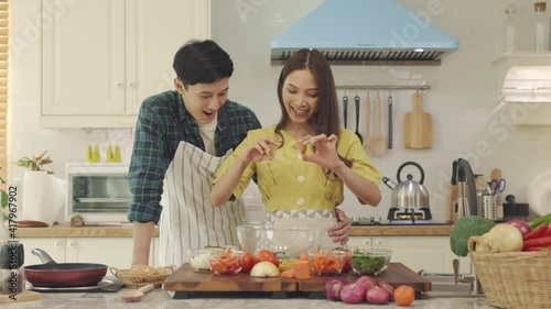 Newly married couple Help each other cook happily, having fun at home. Couples spend time together making lovely, happy meals.
