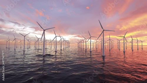 A lot of spinning wind turbines farm out in the sea turning under a beautiful burning summers sunset. Fly trough 3D animation photo