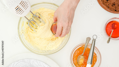 Картината върху платно Woman hands add vanilla extract intoa bowl with butter cream