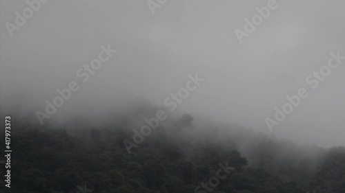 Mist of water vapor drifted from top of mountain to dark blue sky.