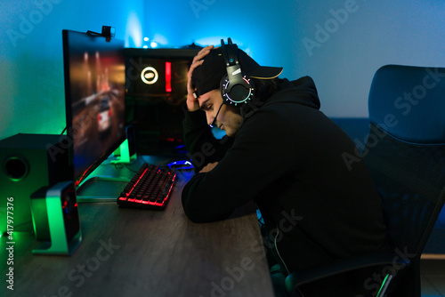 Sad young man losing a game match on his gaming computer