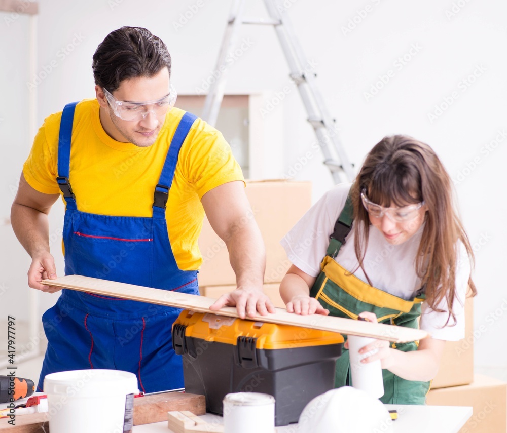 Man explaining woman woodworking tips in wood workshop Man explaining woman woodworking tips in wood workshop