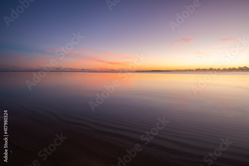 Fototapeta Naklejka Na Ścianę i Meble -  Peaceful dawn, colorful sky, smooth sea over wavy sands, island on horizon. Iriomote Island.