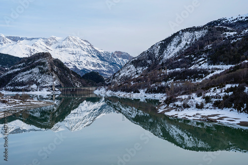 Snow-capped Pyrenees mountains reflected in the waters of the Lanuza reservoir