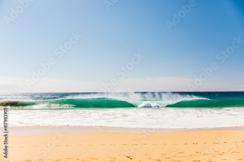 wave crashing on the shore blue sky