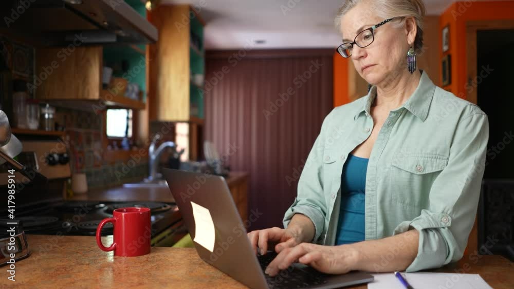 Thoughtful serious mature woman working on laptop computer thinking solving problem. Concept of work from home businesswoman, teacher, tutor