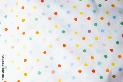 Fabric background with pattern. Rainbow balls on the fabric.