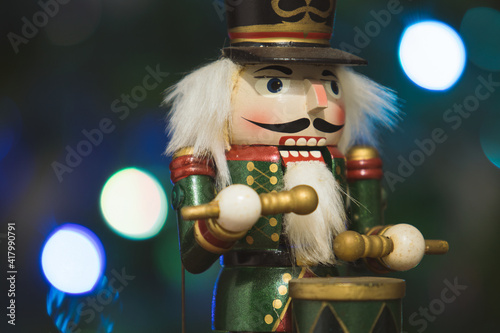 Festive nutcracker soldier with bokeh blurred fairy light.