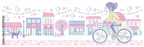 春の桜の街並みで自転車に乗る女性