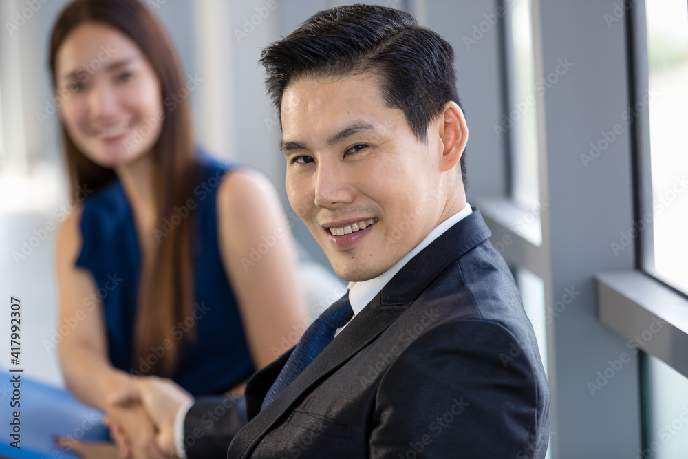 Cheerful ethnic business partners shaking hands in office Cheerful ethnic business partners shaking hands in office