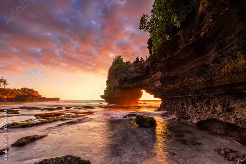 Dramatic Sunset color at Batu Bolong temple and Tanah Lot, Tabanan, Bali. beautiful view with the coral reef in low tide.