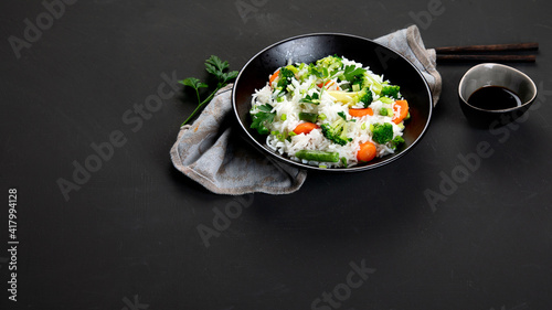 Healthy vegan rice with boiled broccoli, carrot and spring onion