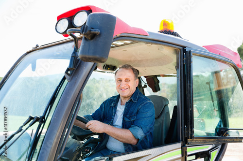 Portrait of diligent male farmer in the special car at the cow farm.