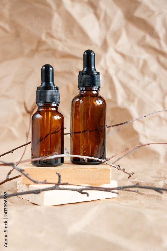 Cometic bottles made of amber glass on crumpled craft paper. Skin care products packaging design. Spa concept. Cometic bottles made of amber glass on crumpled craft paper. Skin care products packaging design. Spa concept.