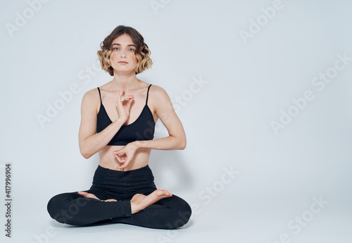 Woman meditates on a light background yoga asana © SHOTPRIME STUDIO