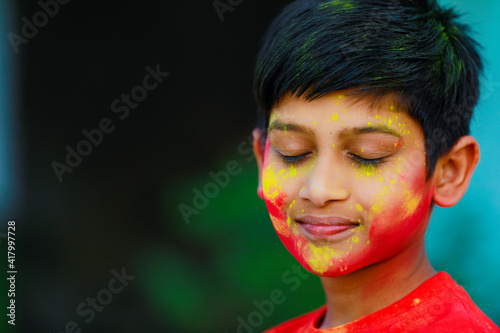 Cute indian little child playing holi. Holi is colors festival in india