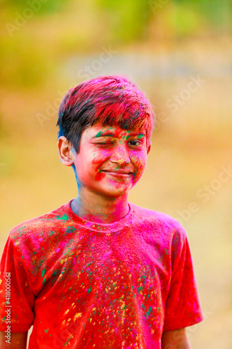 Holi celebrations -Indian little boy playing Holi and showing face expression.