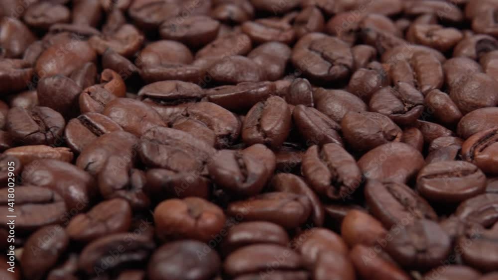 Roasted coffee bean. Fragrant coffee seeds. Slow Motion Close Up of Whole Roasted Coffee Beans. Roasted coffee bean. Fragrant coffee seeds. Slow Motion Close Up of Whole Roasted Coffee Beans.