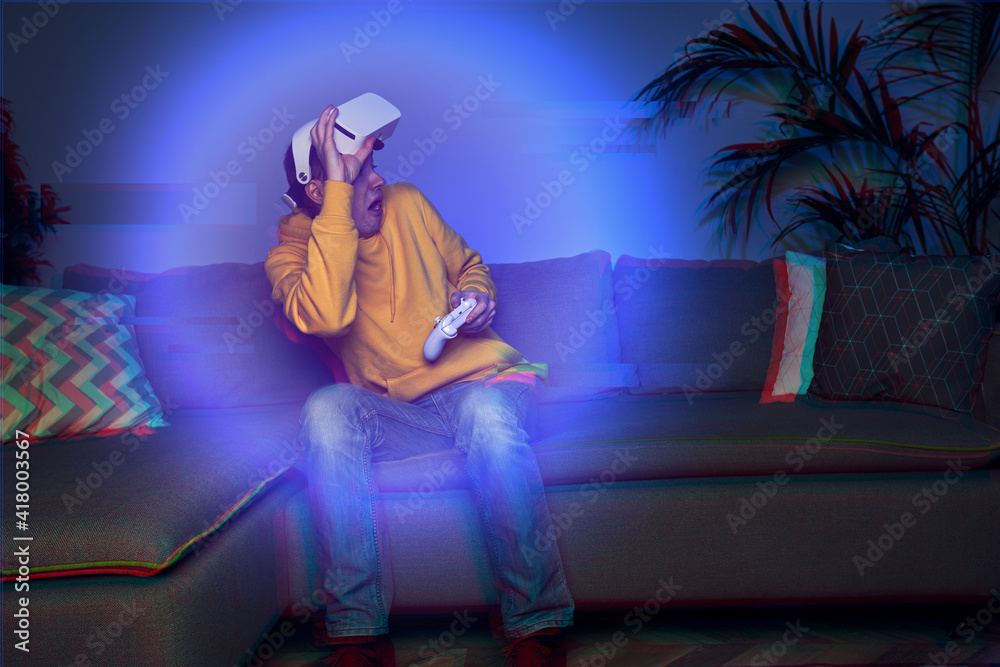 Fototapeta premium Man playing game at home using vr headset