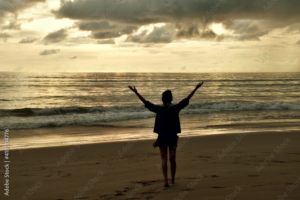 Fototapeta premium Young woman working on the beach with sunset