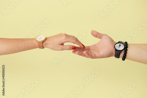 Young couple holding hands on color background