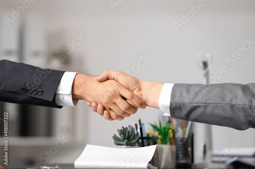 Businessmen shaking hands in office