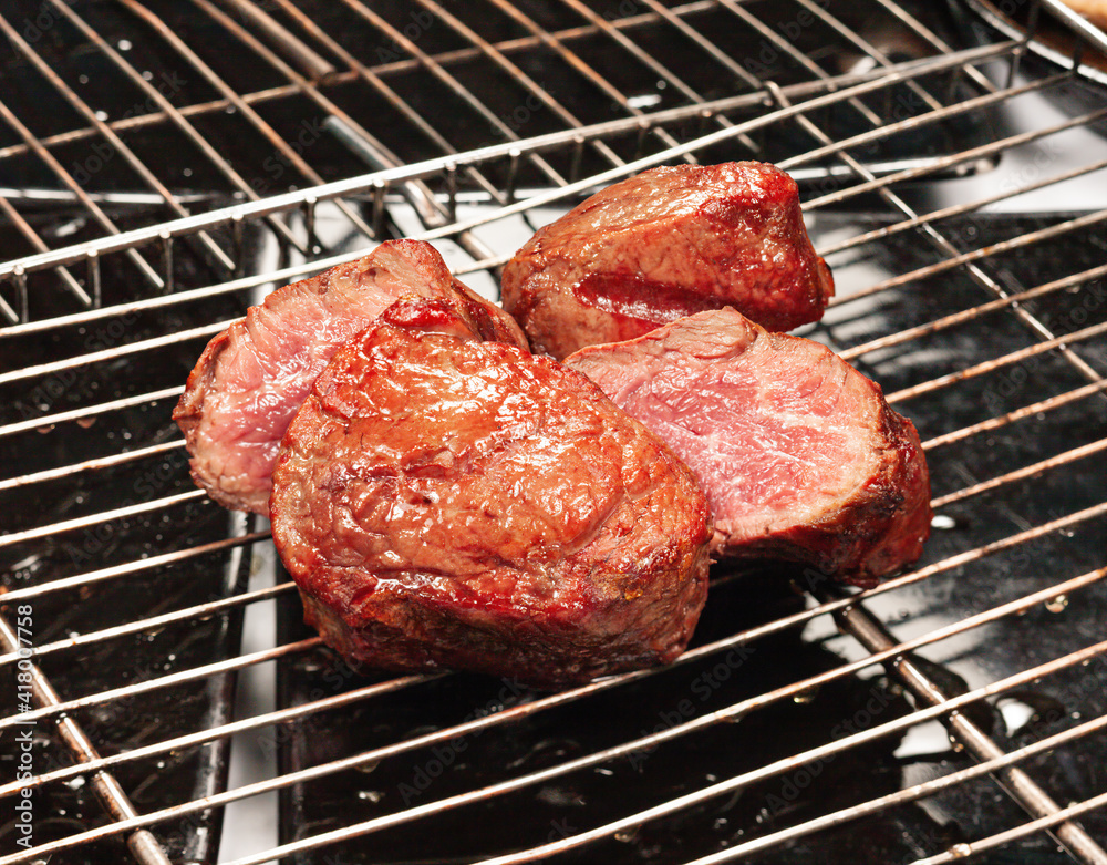 The meat is cooked on the grill with the grill The meat is cooked on the grill with the grill