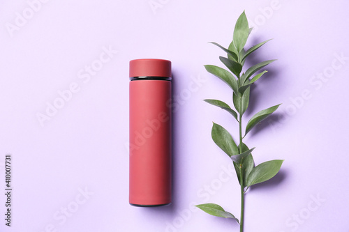 Modern thermos on color background photo