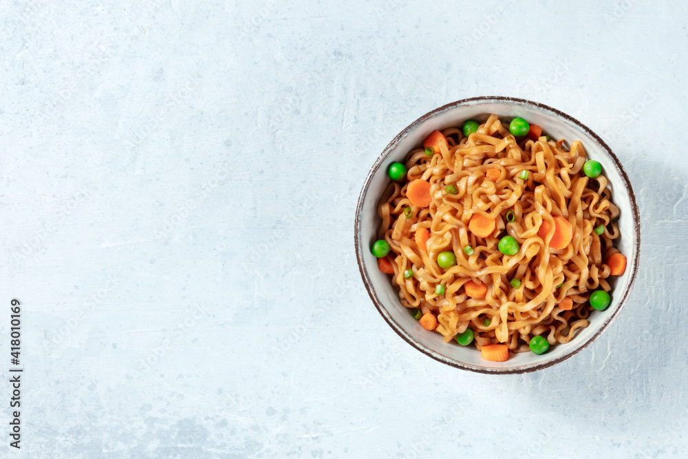Noodles with green peas and carrots, shot from above with copy space Noodles with green peas and carrots, shot from above with copy space