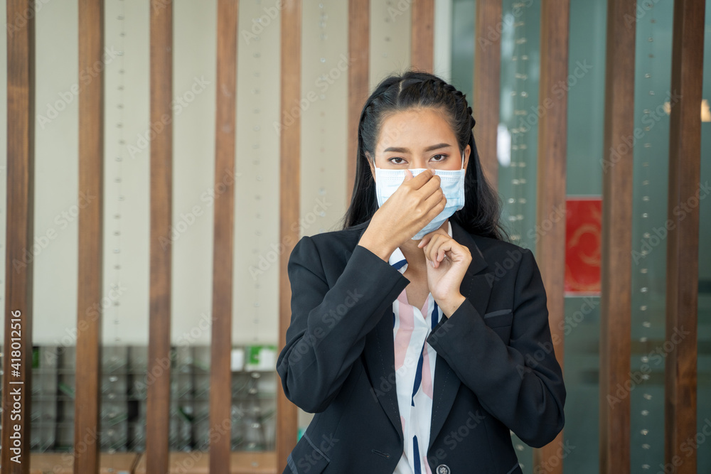 Portrait of receptionist wearing protective mask to Protect Against Covid-19 behind the counter in the hotel,Coronavirus has turned into a global emergency. Portrait of receptionist wearing protective mask to Protect Against Covid-19 behind the counter in the hotel,Coronavirus has turned into a global emergency.