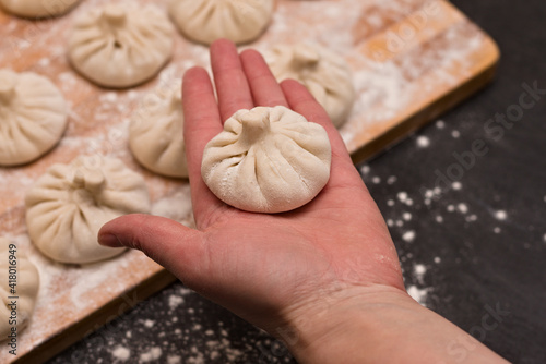 Freshly cooked raw traditional Georgian dish khinkali in the palm of the chef.