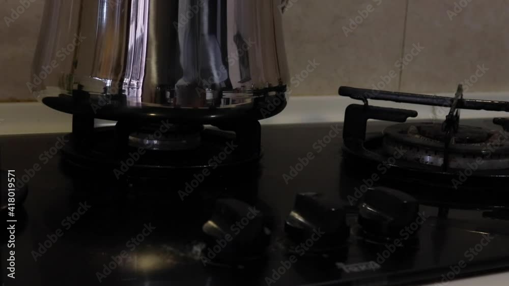 turning on gas stove with kettle on it - medium turning on gas stove with kettle on it - medium
