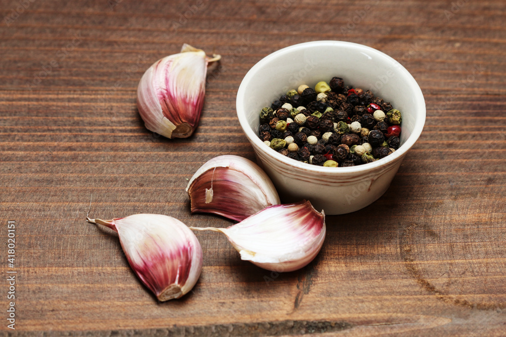 Pepper grains and garlic on a wooden table. Pepper grains and garlic on a wooden table.