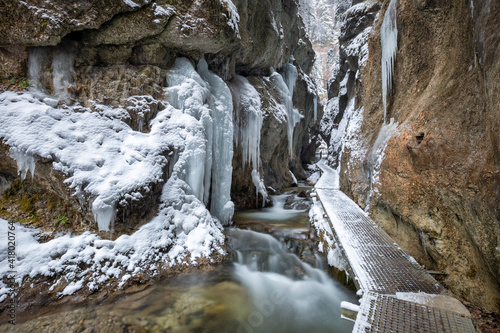 Fototapeta Naklejka Na Ścianę i Meble -  Winter landscape with a wild stream and waterfalls through a narrow gorge and canyon covered with snow and ice. The Mala Fatra national park in Slovakia, Europe.