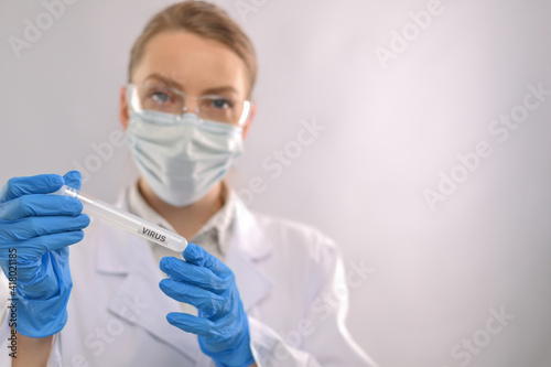 Doctor or scientist working on a vaccine against coronavirus on a light background in a laboratory