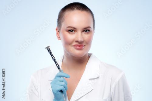 Portrait of a woman dermatologist holding cosmetic device attachment