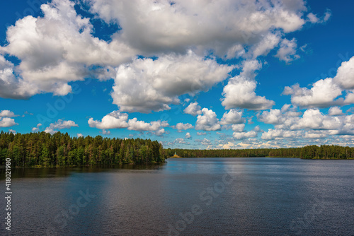 Large curly clouds over the beautiful Roshchinsky lake near the walls of the monastery. Holy Trinity Alexander Svirsky Monastery in the Leningrad region, known for architectural monuments.