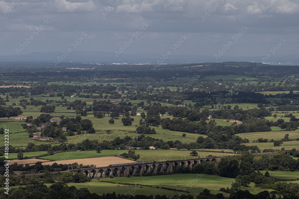 A panoramic British view with a train track viaduct visible in the distance A panoramic British view with a train track viaduct visible in the distance