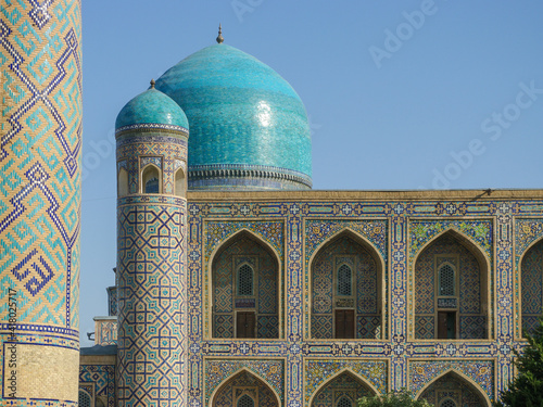 Arches, domes and minaret with beautiful mosaic decoration on ancient Tilya Kori madrassa in UNESCO listed Samarkand, Uzbekistan