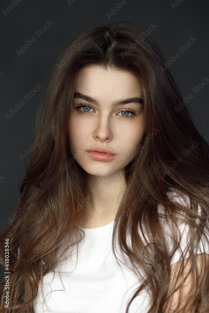 Close-up portrait of a young beautiful woman, on a dark background. Beauty portrait of a girl, studio tests. Close-up portrait of a young beautiful woman, on a dark background. Beauty portrait of a girl, studio tests.