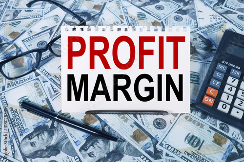 Profit Margin. text on white paper on the background of calculator and money bills