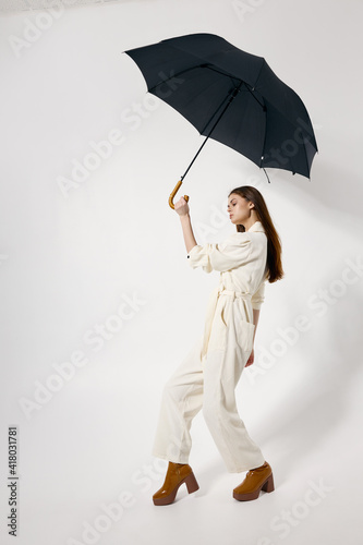 fashionable woman with open umbrella over her head protection from the rain brown boots modern style