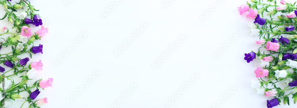 spring bouquet of purple, white and pink bell flowers over white wooden background. top view, flat lay spring bouquet of purple, white and pink bell flowers over white wooden background. top view, flat lay