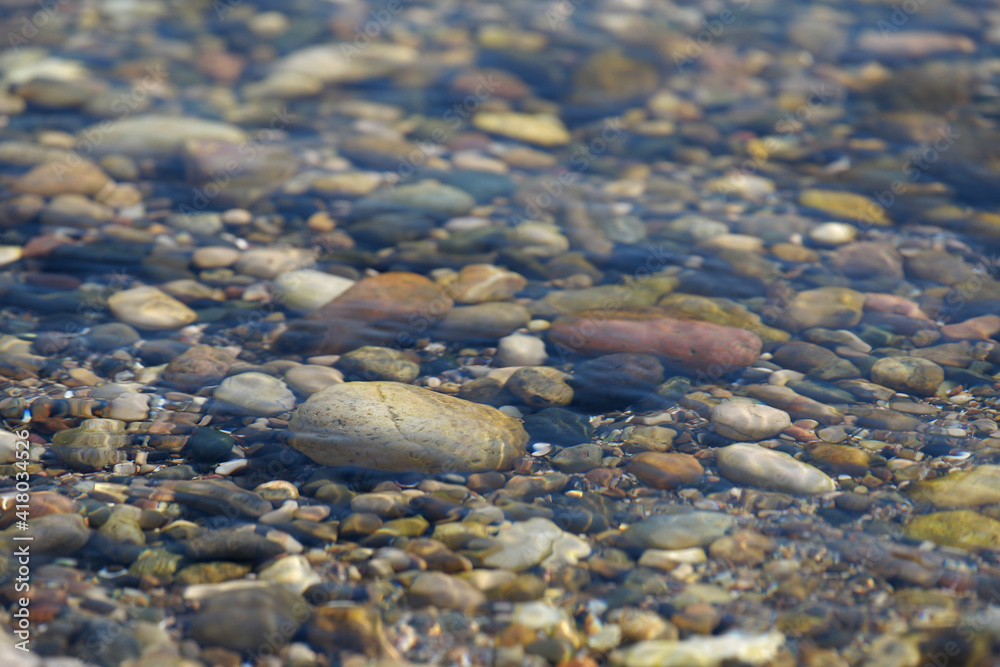 small sea pebbles in the water. Smooth stones