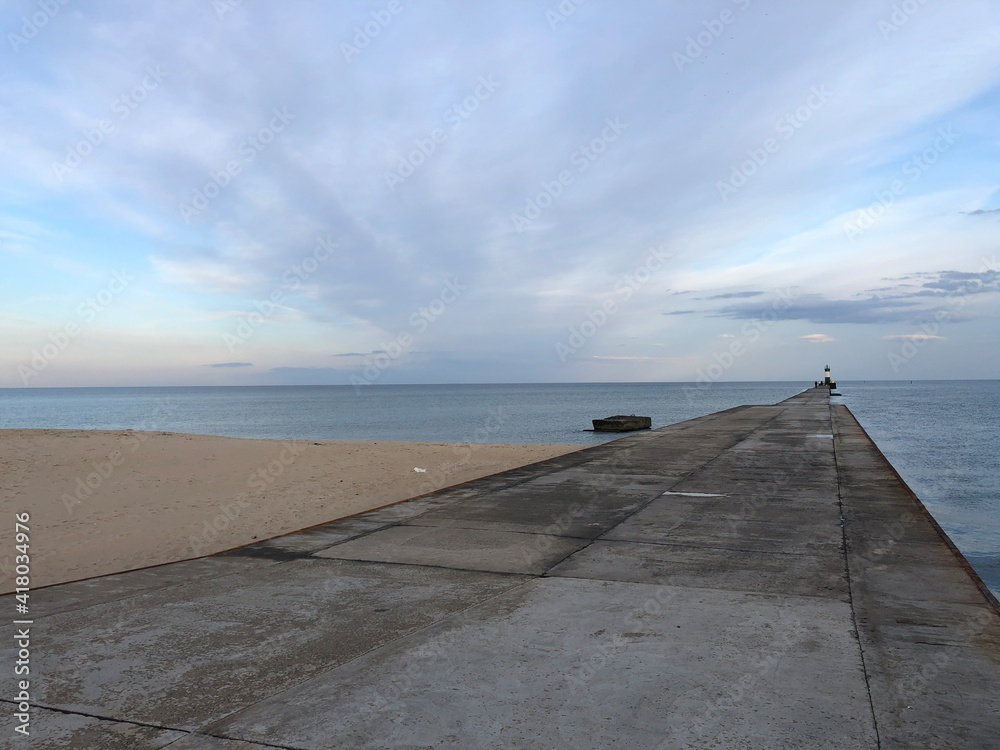 calm sea with sandy shore and gentle sunset