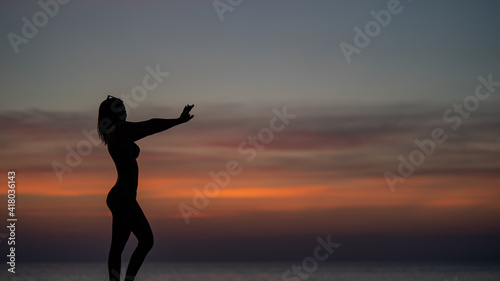 Silhouette portrait of woman wearing bikini on the beach  golden sunset moment. Holiday and travelling concept.