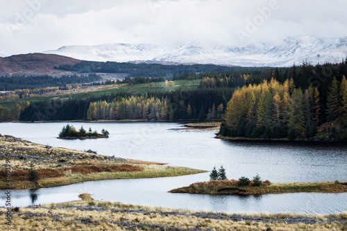 Fototapeta Naklejka Na Ścianę i Meble -  Autumn landscape in Highlands, Scotland, United Kingdom. Beautiful mountains with snow in background.